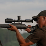 Hunter shouldering a bolt-action rifle mounted with the RIX TOURER T50 4K riflescope at dusk