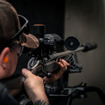 Hunter aiming a rifle fitted with the RIX TOURER T50 4K day and night vision riflescope on a shooting rest